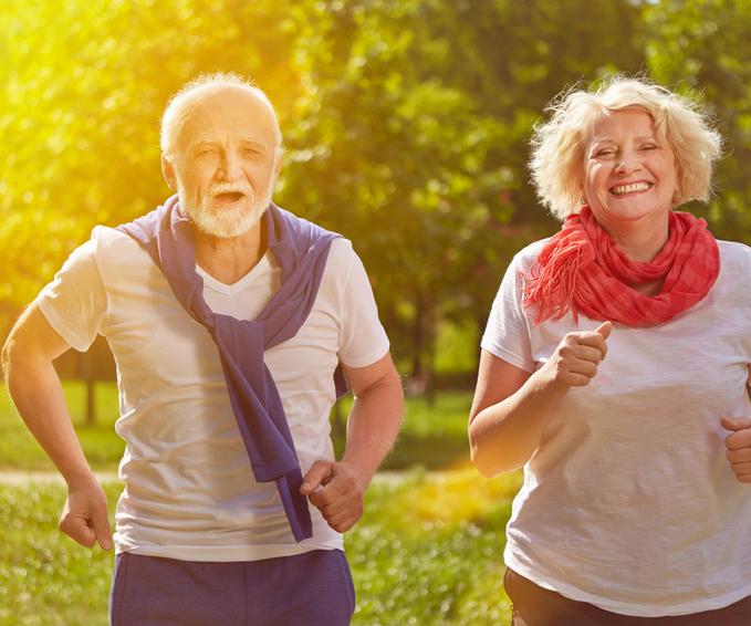 Zwei glückliche Senioren beim Jogging im Park im Sommer